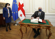 In this photo provided by the Georgian Presidential Press Office, European Council President Charles Michel signs the guest book as Georgia's President Salome Zurabishvili looks on in Tbilisi, Georgia, Monday, March 1, 2021 (Georgian Presidential Press Office via AP)
