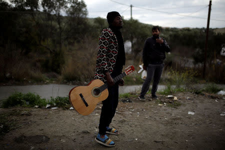 A migrant from Congo holds a guitar at a makeshift camp for refugees and migrants next to the Moria camp on the island of Lesbos, Greece, November 30, 2017. REUTERS/Alkis Konstantinidis