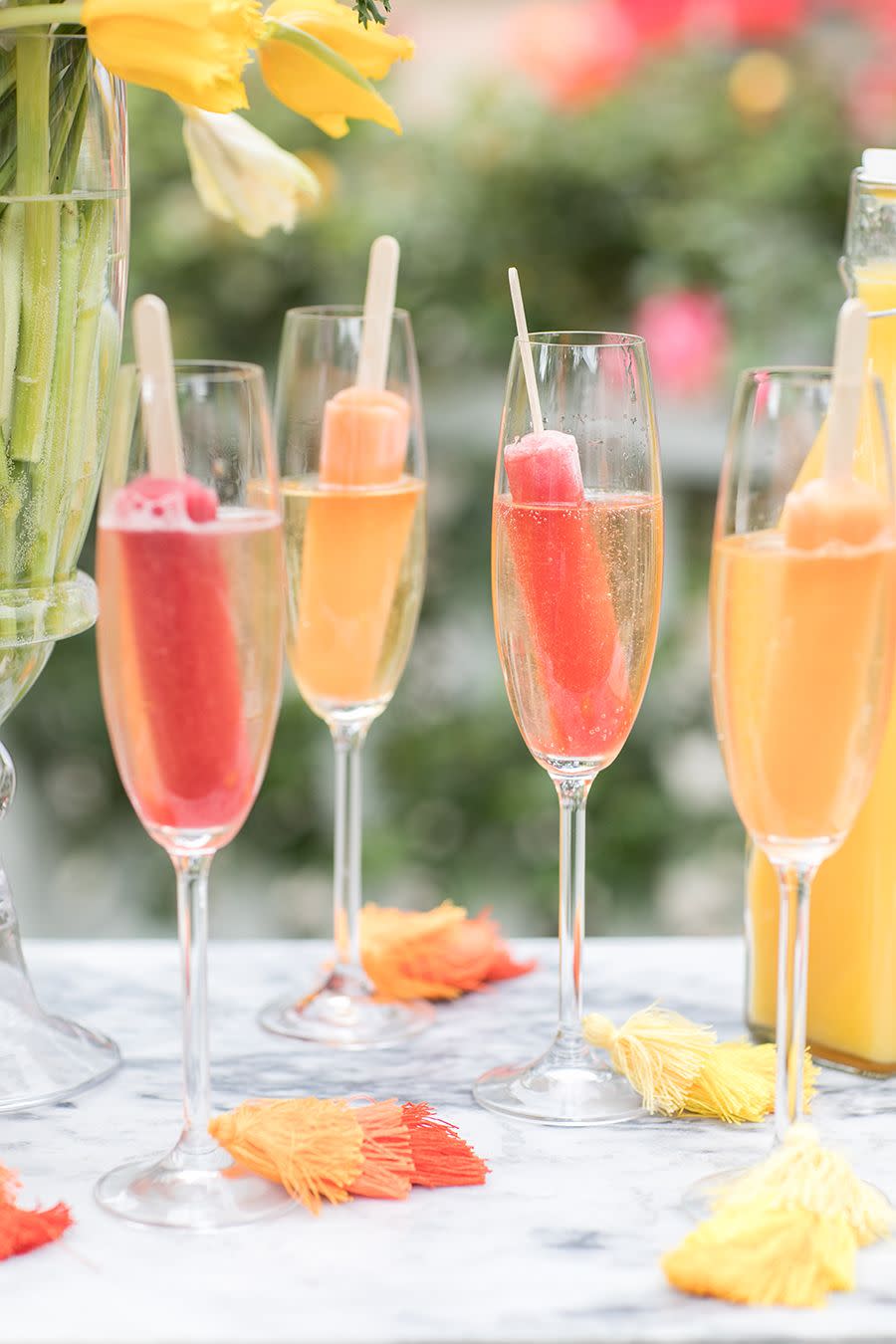 <p>Freeze fruit juices into popsicles then stick them in champagne flutes. Just when you thought bubbly couldn't get any better. </p><p>See more at <a href="https://sugarandcharm.com/2018/05/a-college-graduation-bubbly-bar.html?section-2" rel="nofollow noopener" target="_blank" data-ylk="slk:Sugar and Charm;elm:context_link;itc:0;sec:content-canvas" class="link ">Sugar and Charm</a>.</p>
