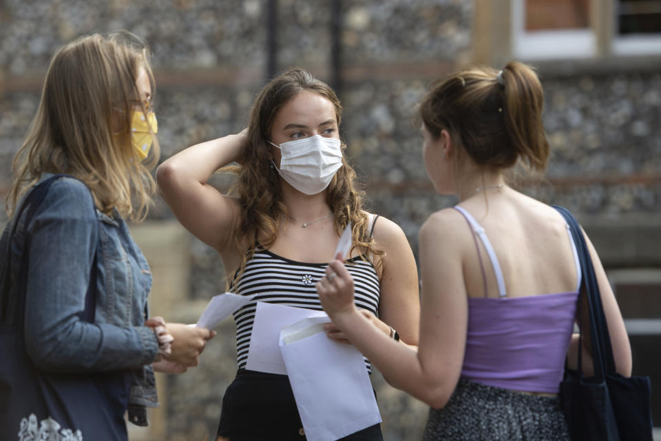 Students at Norwich School, Norwich, England, receive their A-Level results on Thursday Aug. 13, 2020. Thousands of school-leaving children in Britain have been left distraught after finding out Thursday that they were given lower-than-expected grades, with many questioning how the results were calculated after the coronavirus pandemic cancelled exams key for college applications. (Joe Giddens/PA via AP)