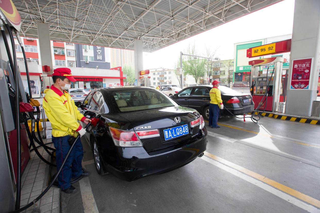 Staff refuel cars at a PetroChina gas station.