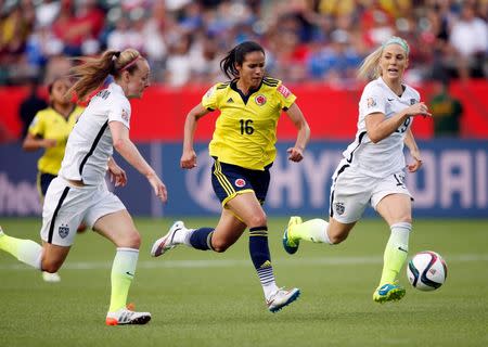 Jun 22, 2015; Edmonton, Alberta, CAN; Colombia forward Lady Andrade (16) moves the ball against United States defender Becky Sauerbrunn (4) and defender Julie Johnston (19) during the second half in the round of sixteen in the FIFA 2015 women's World Cup soccer tournament at Commonwealth Stadium. Mandatory Credit: Michael Chow-USA TODAY Sports