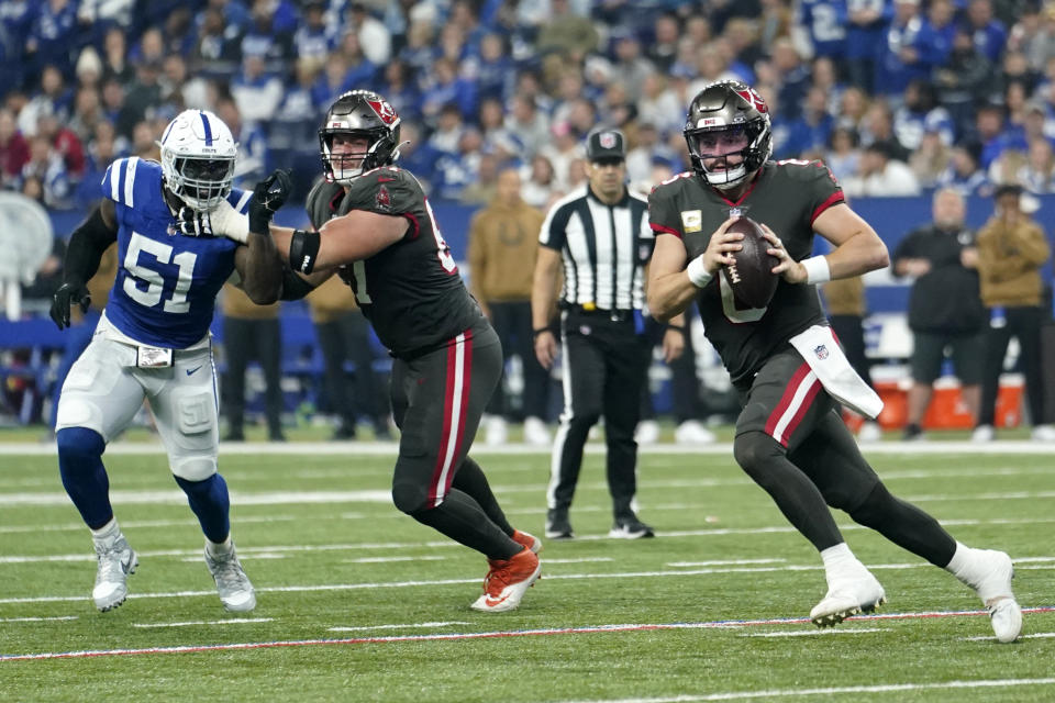 Tampa Bay Buccaneers quarterback Baker Mayfield, right, scrambles during the first half of an NFL football game against the Indianapolis Colts Sunday, Nov. 26, 2023, in Indianapolis. (AP Photo/Michael Conroy)