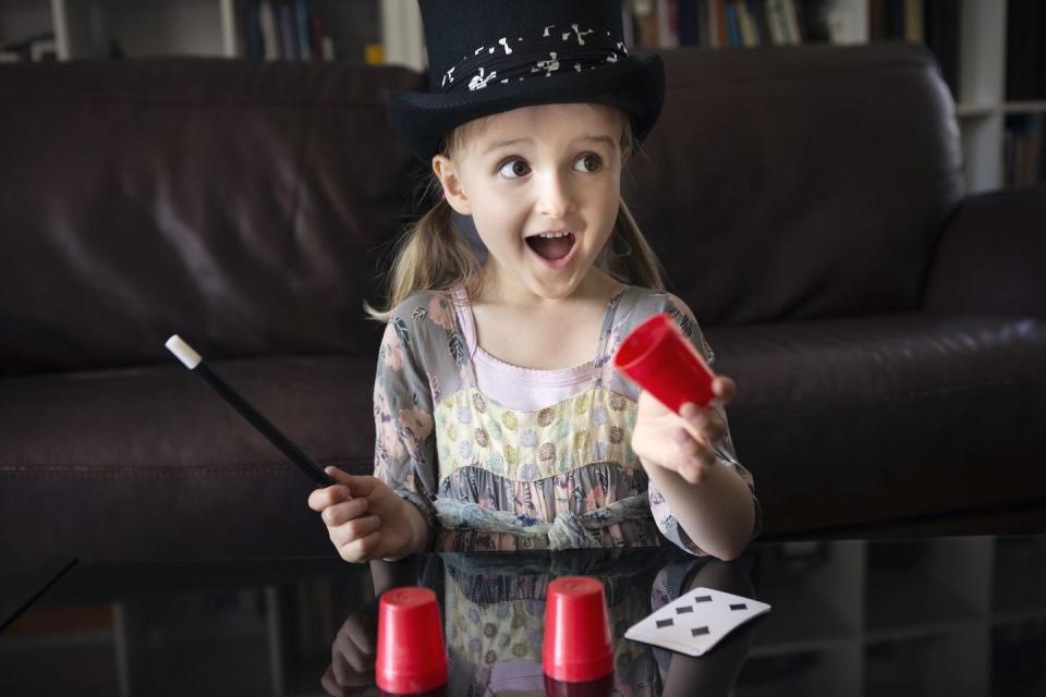 young girl in top hat performing magic trick fun activities for kids
