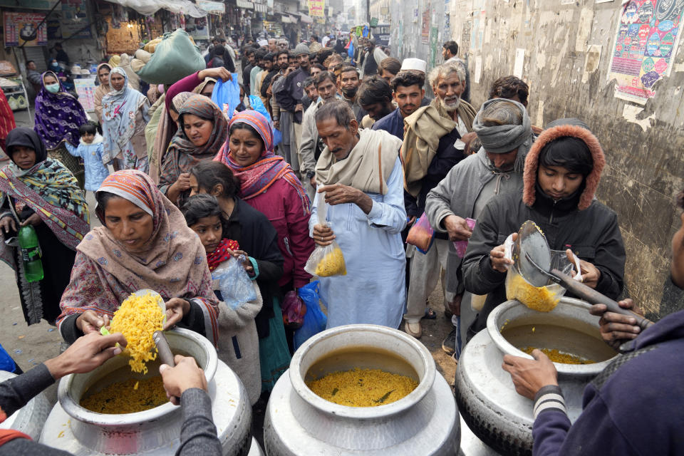 Pakistani people receive free food outside the Data Darbar shrine in Lahore, Pakistan, on Saturday, Feb. 10, 2024. (AP Photo/K.M. Chaudary)