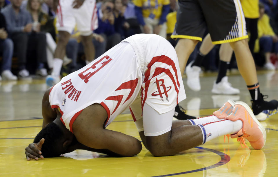 Houston Rockets' James Harden kneels on the court with an apparent injury during the first half of Game 2 of the team's second-round NBA basketball playoff series against the Golden State Warriors in Oakland, Calif., Tuesday, April 30, 2019. (AP Photo/Jeff Chiu)