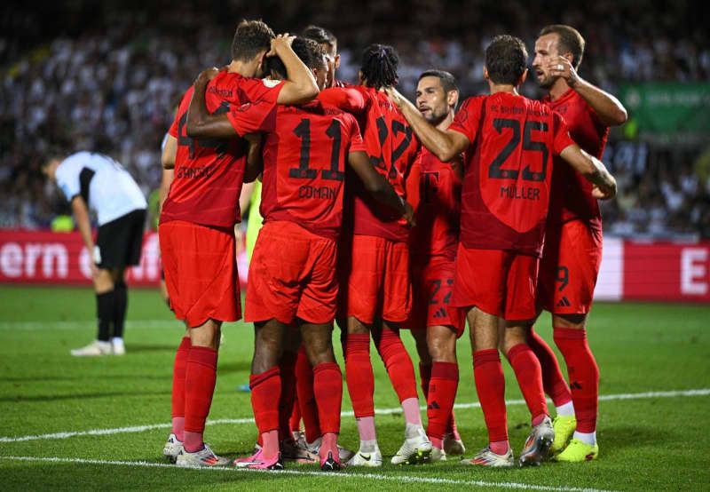 Munich's Kingsley Coman celebrates with his teammates his team's third goal during the DFB Cup match between SSV Ulm 1846 and Bayern Munich at the Donaustadion. Tom Weller/dpa