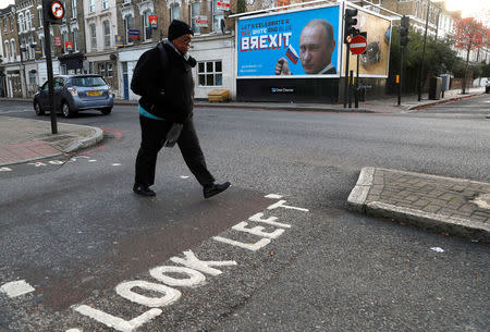 A woman walks past a billboard poster in London, Britain, November 8, 2018. REUTERS/Peter Nicholls