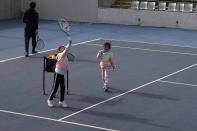 Children play tennis near the Diamond Court in Beijing, Sunday, Nov. 21, 2021. According to photos released by the organizer, missing tennis star Peng Shuai reappeared in public Sunday at a youth tournament in the court compound in Beijing, as the ruling Communist Party tried to quell fears abroad while suppressing information in China about Peng after she accused a senior leader of sexual assault. (AP Photo/Andy Wong)