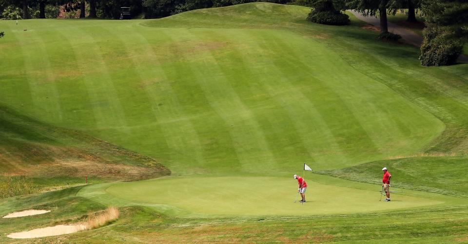 Golfers putt on the green of hole no.  9 of the Olympic Course at Gold Mountain Golf Course.  The city owned complex has changed management companies and invested in several facilities or course upgrades in recent years with Daryl Matheny as general manager.  The longtime Kitsap resident began working at the course more than three decades ago.