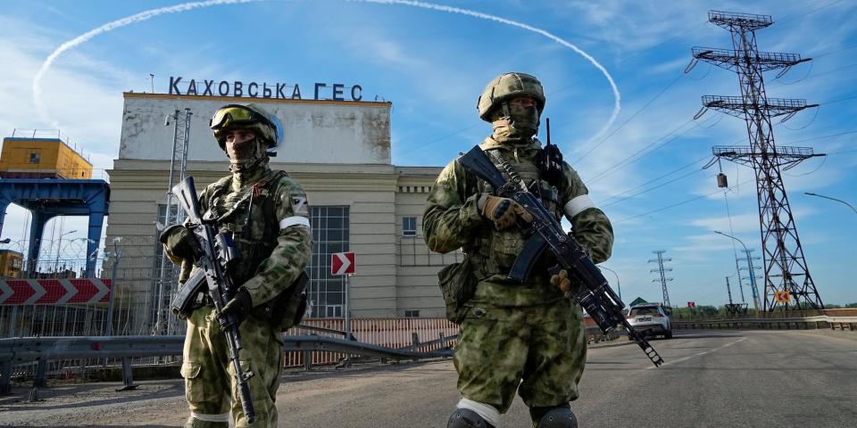 Russian troops guard an entrance of the Kakhovka Hydroelectric Station, a run-of-the-river power plant on the Dnieper River in Kherson region, southern Ukraine, Friday, May 20, 2022, during a trip organized by the Russian Ministry of Defens