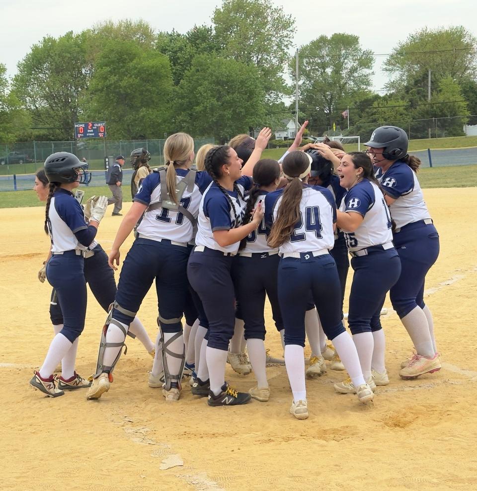The Howell softball team celebrates at home plate after Madison Winemiller's three-run homer.