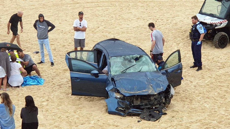 Rescue workers at the scene of a car crash on Maroubra beach. 