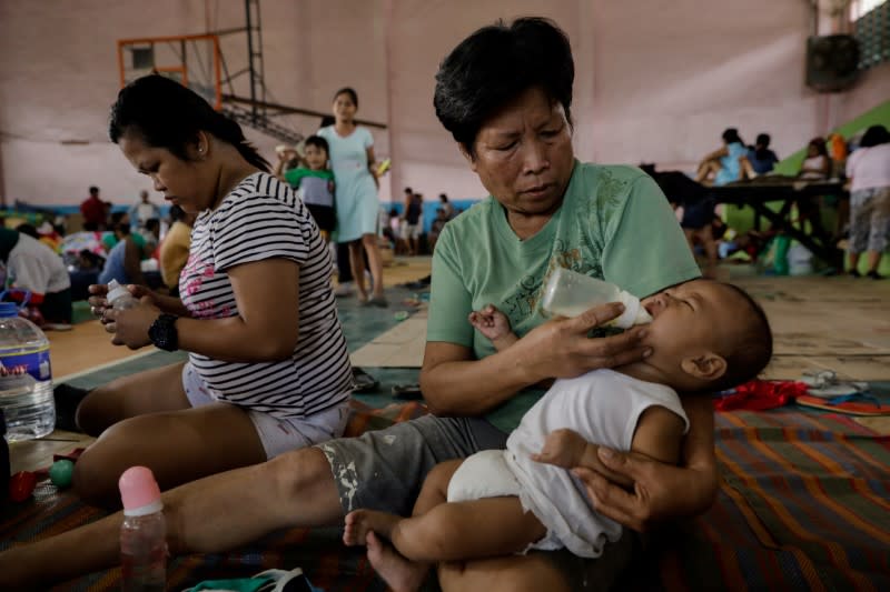 Macaya feeds her grandchild in an evacuation center for residents affected by Taal Volcano's eruption in Santo Tomas