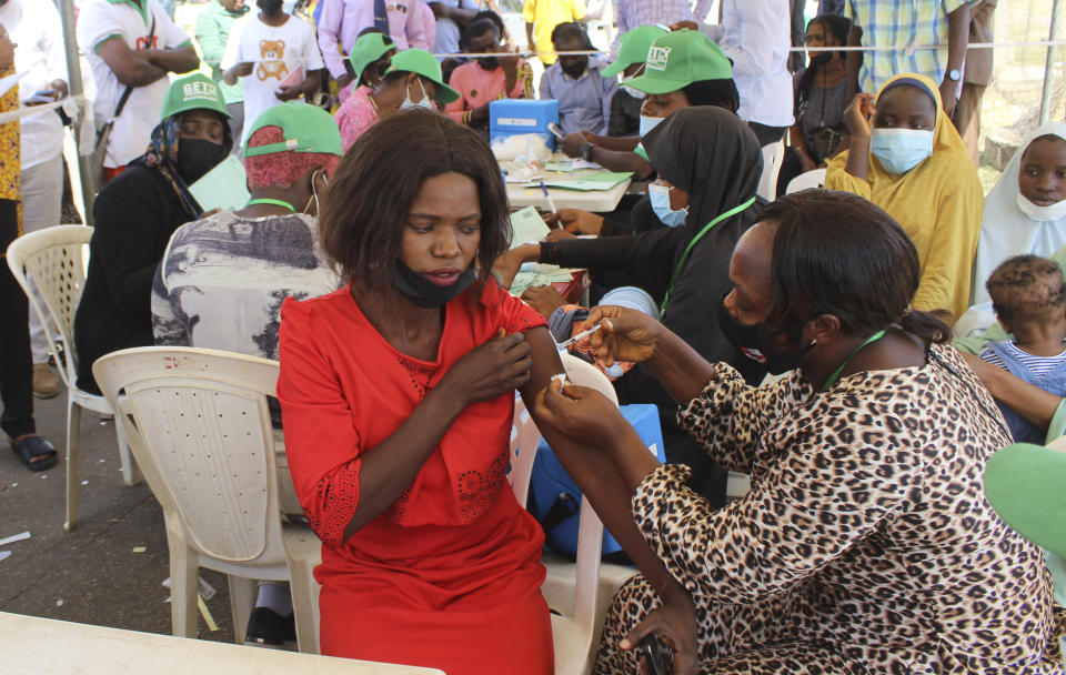 A Nigeria civil servant receives an AstraZeneca coronavirus vaccine, before she is allow access to her office in Abuja, Nigeria , Wednesday, Dec. 1, 2021. Nigeria has detected its first case of the omicron coronavirus variant in a sample it collected in October, weeks before South Africa alerted the world about the variant last week, the country's national public health institute said Wednesday. (AP Photo/Gbemiga Olamikan)