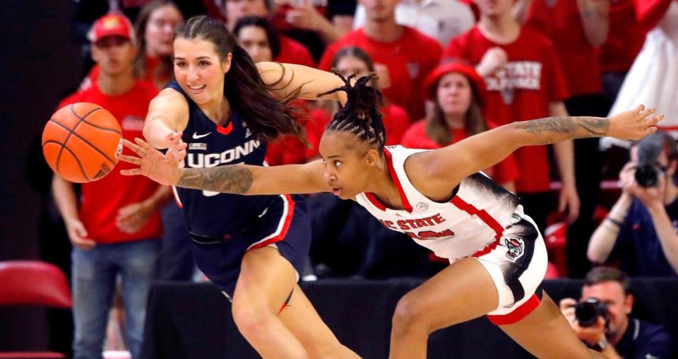 N.C. State’s Aziaha James and UConn’s Caroline Ducharme dive after a loose ball during the second half of the Wolfpack’s 92-81 win on Sunday, Nov. 12, 2023, at Reynolds Coliseum in Raleigh, N.C.