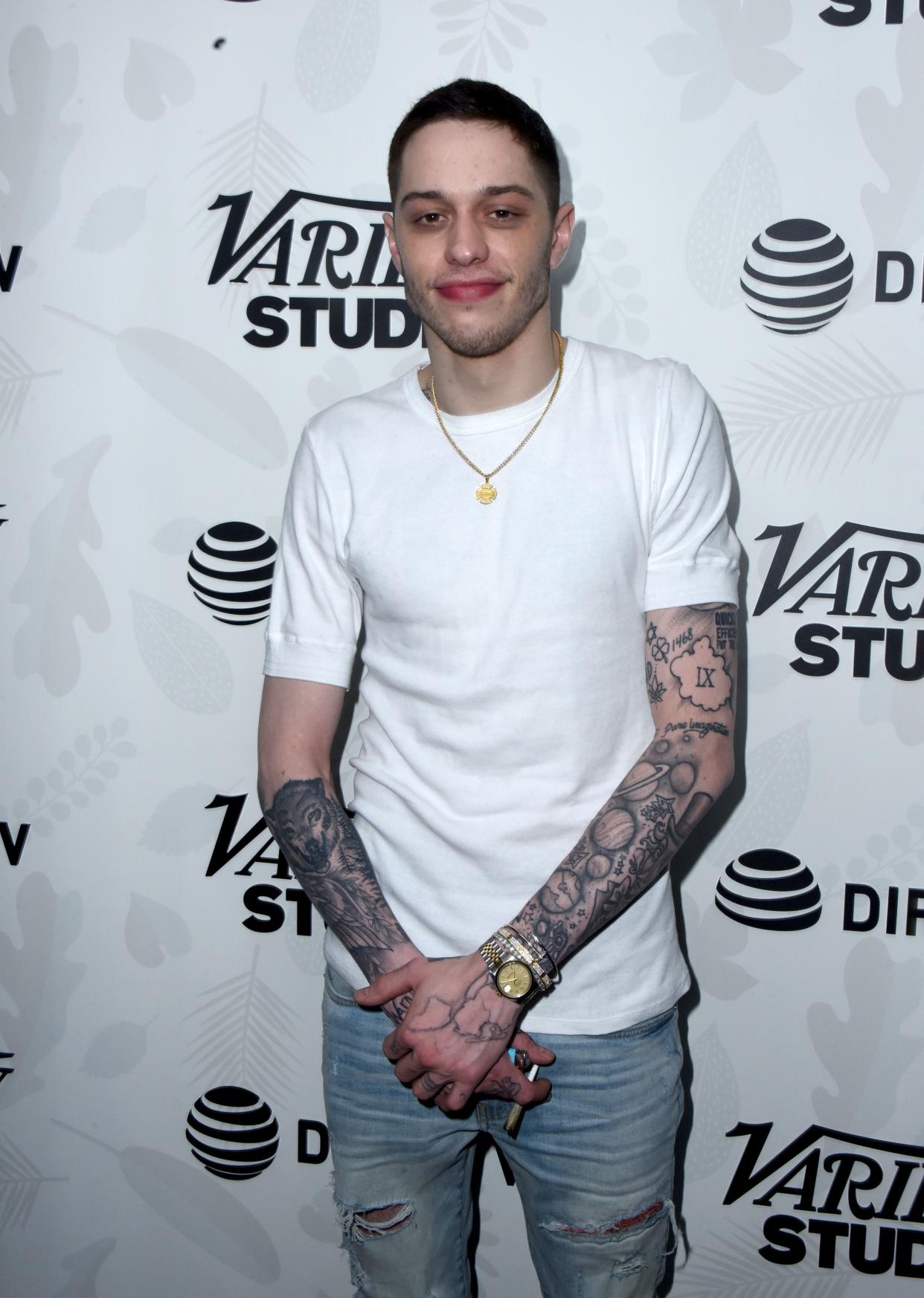 Pete Davidson looks cute in white T-shirt and denim pant with his hands crossed