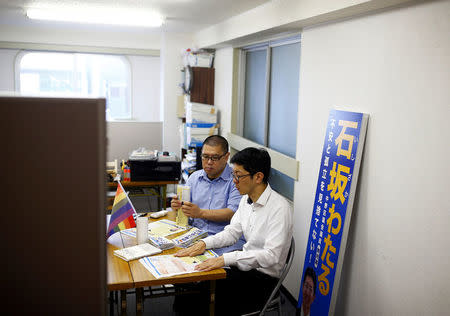 Local politician and LGBT activist Wataru Ishizaka (R) and his partner Yasunobu Akasugi fold campaign posters in Ishizaka's office in Tokyo, Japan, June 22, 2016. REUTERS/Thomas Peter