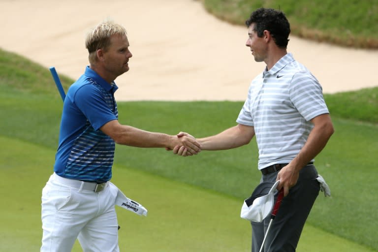 Soren Kjeldsen (L) of Denmark shakes hands with Rory McIlroy of Northern Ireland after round one of the World Golf Championships Match Play, at the Austin Country Club in Texas, on March 22, 2017