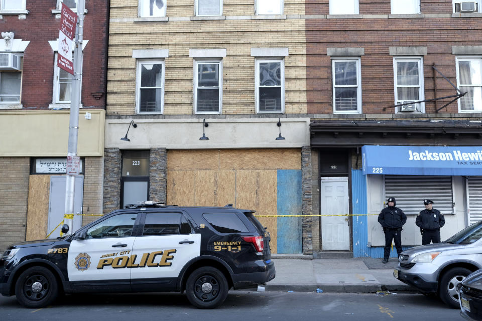 Police officers stand near the scene of a gun fight at a kosher supermarket in Jersey City, N.J., Thursday, Dec. 12, 2019. Investigators are looking to pinpoint what prompted a deadly attack on the Jewish market in Jersey City amid fears that it was motivated by anti-Semitism, as a nearby school reopened Thursday. (AP Photo/Seth Wenig)