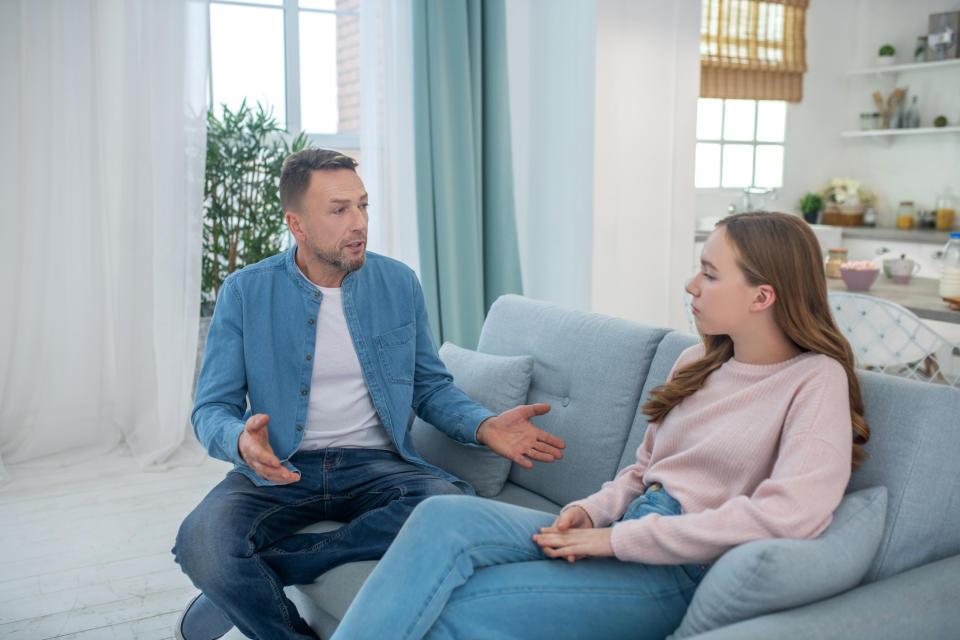 A parent talking to their child on a couch