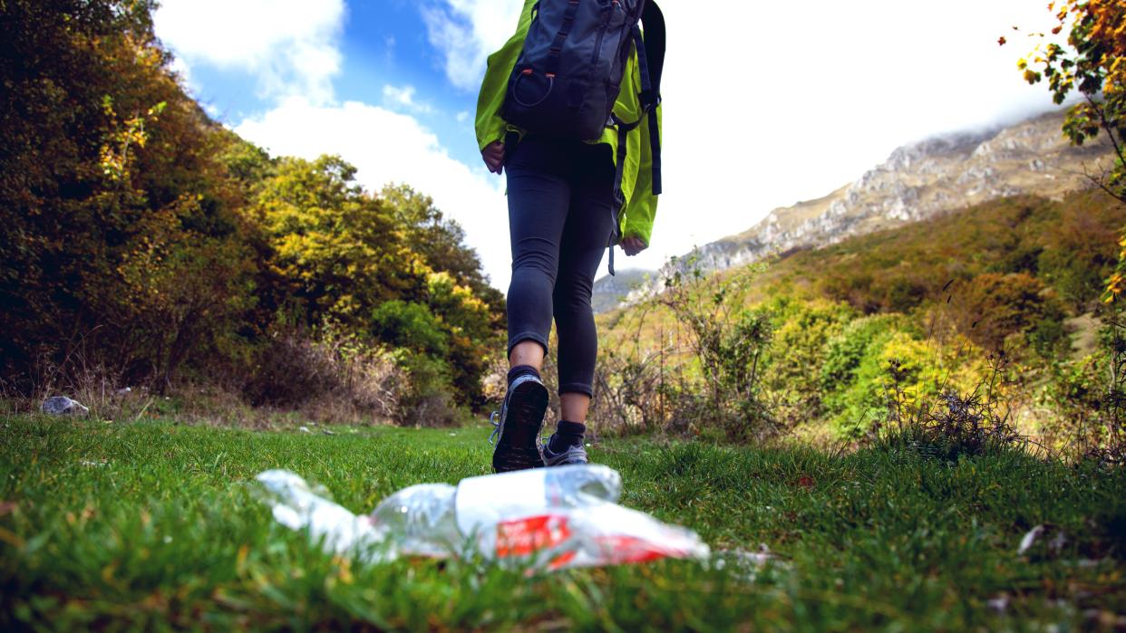  Careless climbers in mountain trashing water bottle on the grass. 