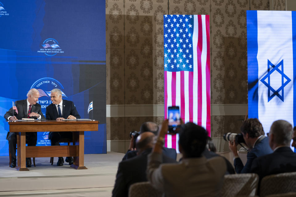 U.S. President Joe Biden and Israeli Prime Minister Yair Lapid sign a joint declaration affirming the "unbreakable bonds" between the two countries and a U.S. commitment to protecting Israeli security, in Jerusalem, Thursday, July 14, 2022. (AP Photo/Evan Vucci)