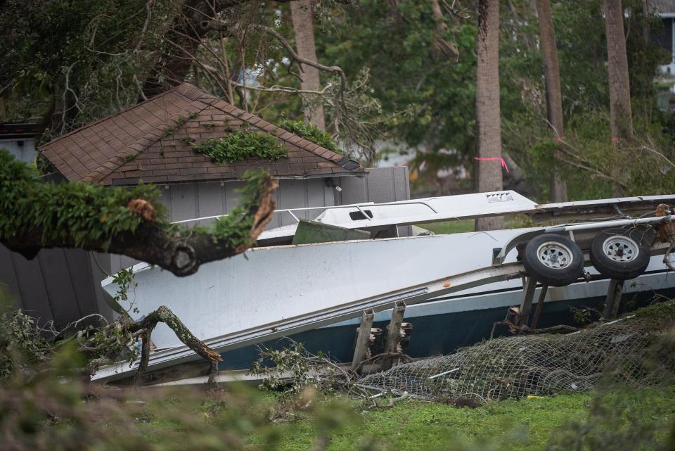 An overturned boat sits off of Ellison Wilson Road in Palm Beach Gardens in the aftermath of a Saturday evening tornado.