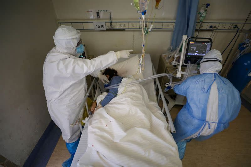 Medical workers in protective suits attend to a patient inside an isolated ward of Wuhan Red Cross Hospital in Wuhan, the epicentre of the novel coronavirus outbreak