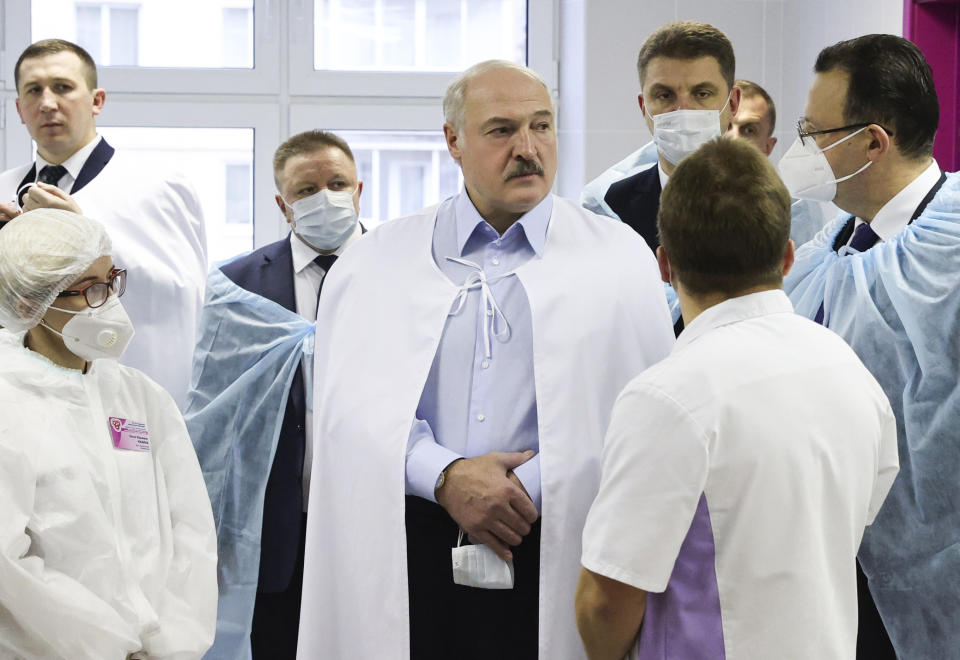 Belarusian President Alexander Lukashenko, centre, listens to medics as he visits a transfusiology center in Minsk, Belarus, Friday, Nov. 27, 2020. (Maxim Guchek/BelTA Pool Photo via AP)