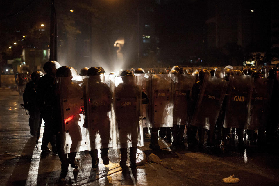 Bolivarian National Guard Officers advance to stop a protest at Plaza Altamira, Caracas, Venezuela, Friday, March 14, 2014. The Venezuelan government is stepping up security operations in Caracas and other cities where demonstrators are blocking streets, avenues and highways. President Nicolas Maduro said that those involved in creating road barricades will be arrested. (AP Photo/Alejandro Cegarra)