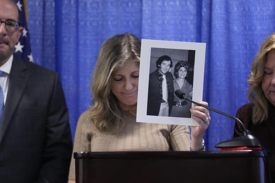 Randi Childs, daughter of Sheila Heiman, holds up a picture of her mother and father while speaking at a news conference after Richard Cottingham appeared remotely in a courtroom in Mineola, N.Y., Monday, Dec. 5, 2022. Cottingham, the serial murderer known as the "Torso Killer", admitted Monday to killing a 23-year-old woman outside a Long Island shopping mall in 1968 and four other women decades ago, including Sheila Heiman. (AP Photo/Seth Wenig)