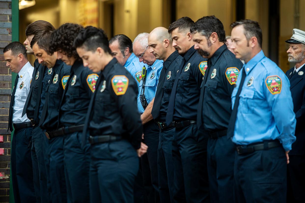 Asheville firefighters bow their heads during a prayer Sept. 11, 2023 at the Asheville Fire Department while honoring the first responders and others killed in the 9/11 attack on the World Trade Center in 2001.