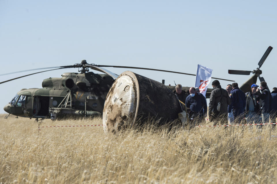 In this handout photo released by Gagarin Cosmonaut Training Centre (GCTC), Roscosmos space agency, a search and rescue team works on the site of landing of the Soyuz MS-15 space capsule near Kazakh town of Dzhezkazgan, Kazakhstan, Friday, April 17, 2020. An International Space Station crew has landed safely after more than 200 days in space. The Soyuz capsule carrying NASA astronauts Andrew Morgan, Jessica Meir and Russian space agency Roscosmos' Oleg Skripochka touched down on Friday on the steppes of Kazakhstan. (Andrey Shelepin, Gagarin Cosmonaut Training Centre (GCTC), Roscosmos space agency, via AP)