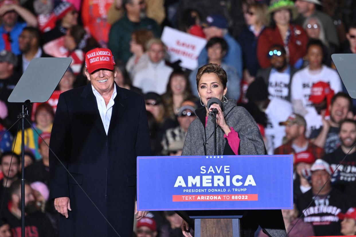 Former President Donald Trump and Kari Lake, whom Trump is supporting in Arizona's gubernatorial race, speak during a rally at the Canyon Moon Ranch festival grounds in Florence, Arizona, southeast of Phoenix, on January 15, 2022.