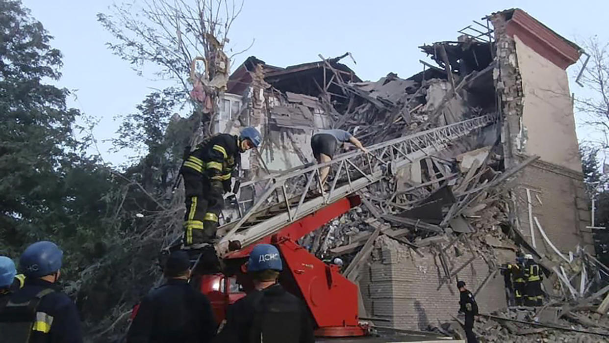 In this photo provided by the Ukrainian Emergency Service, rescuers work at the scene of a building damaged by shelling in Zaporizhzhia, Ukraine, Thursday, Oct. 6, 2022. (Ukrainian Emergency Service via AP)