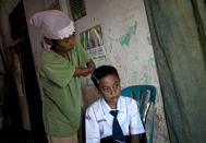 Armless professional photographer Rusidah, 44, combs her twelve-year-old son Nugraha's hair on March 13, 2012 in Purworejo, Indonesia. (Photo by Ulet Ifansasti/Getty Images)