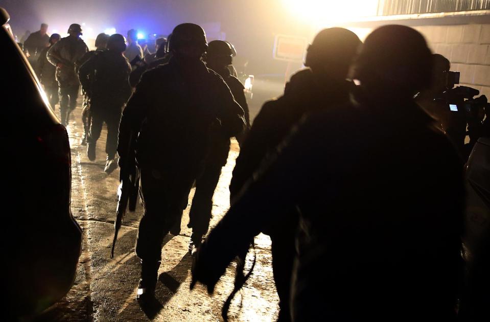 Afghan security forces arrive at the site of a suicide attack in Kabul, Afghanistan, Friday, Jan. 17, 2014. Afghan police say a suicide bomber has attacked a restaurant in central Kabul that is popular with officials, foreigners and business people. There were reports of casualties. (AP Photo/Massoud Hossaini)