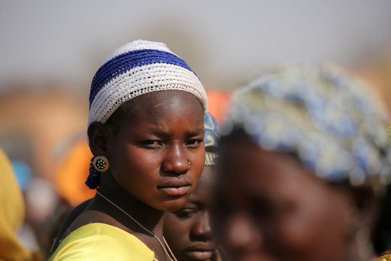 A displaced woman looks on while she waits for help at a village in Dablo area