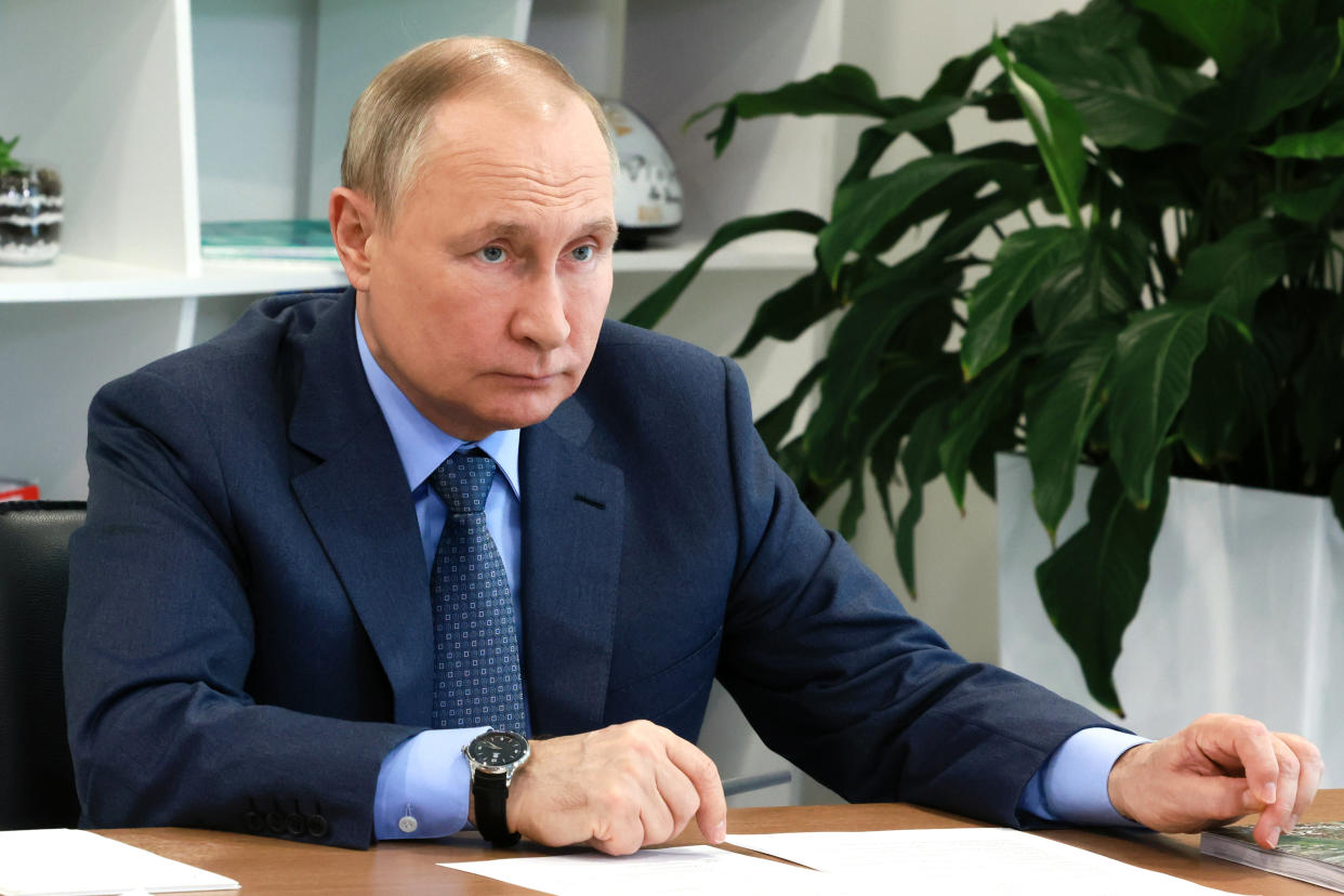 Russian President Vladimir Putin sitting at a desk.