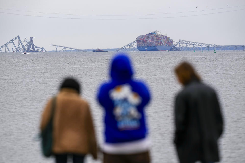 People view from Fort McHenry a container ship as it rests against the wreckage of the Francis Scott Key Bridge, Thursday, March 28, 2024, in Baltimore, Md. (AP Photo/Matt Rourke)