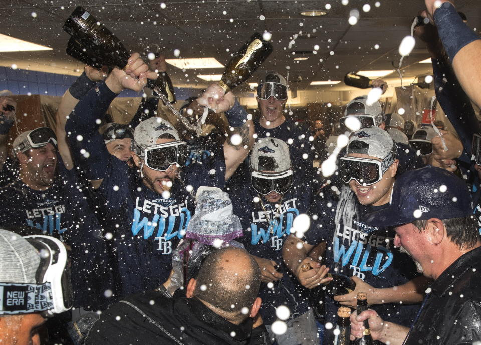 Tampa Bay Rays players celebrate in the clubhouse after they defeated the Toronto Blue Jays and clinched an MLB American League wild-card berth in Toronto, Friday, Sept. 27, 2019. (Fred Thornhill/The Canadian Press via AP)