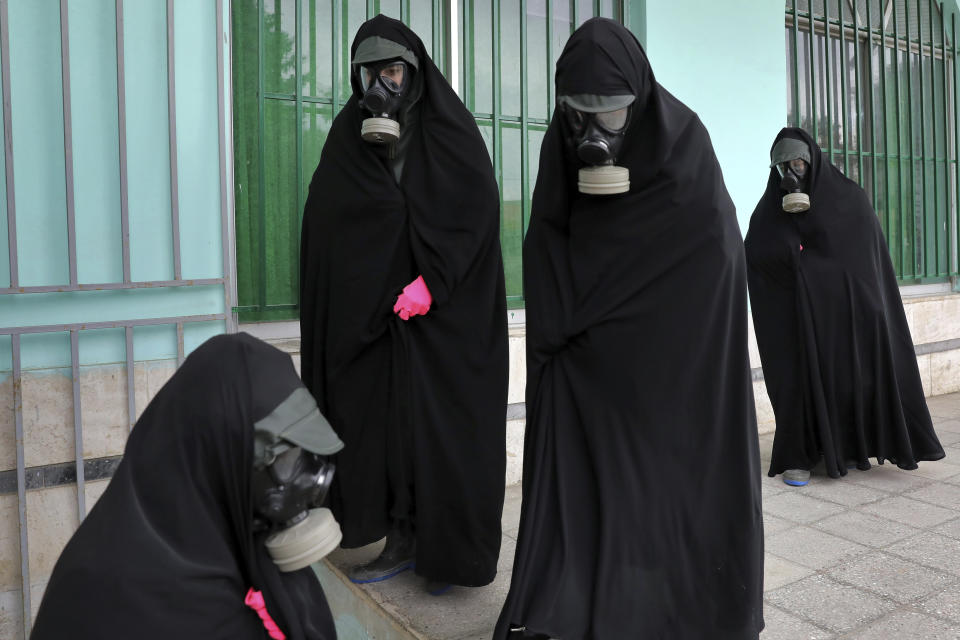 Women clerics wearing protective clothing and "chador," a head-to-toe garment, arrive at a cemetery to prepare the body of a person who died from COVID-19 for a funeral, in Ghaemshahr, Iran, on April 30, 2020. (AP Photo/Ebrahim Noroozi)