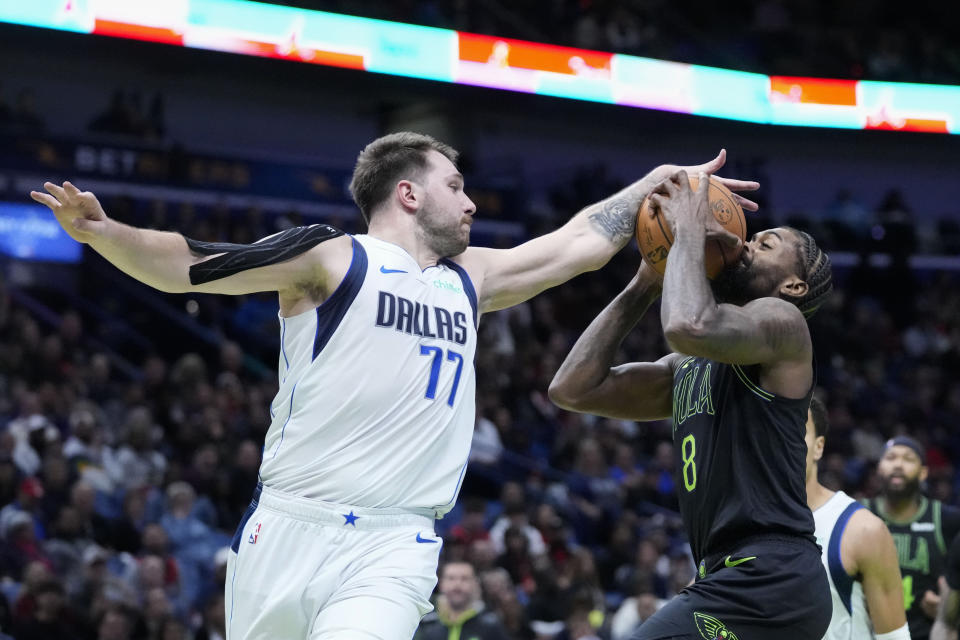 New Orleans Pelicans forward Naji Marshall (8) is stopped by Dallas Mavericks guard Luka Doncic (77) as he drives to the basket in the first half of an NBA basketball game in New Orleans, Tuesday, Nov. 14, 2023. (AP Photo/Gerald Herbert)