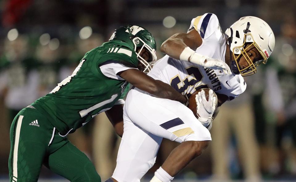 Hoban running back Lamar Sperling, right, drags Nordonia defensive back Bryan Russ as he rushes for a first down during the first half of a Division II regional semifinal football game, Friday, Nov. 12, 2021, in Ravenna, Ohio.