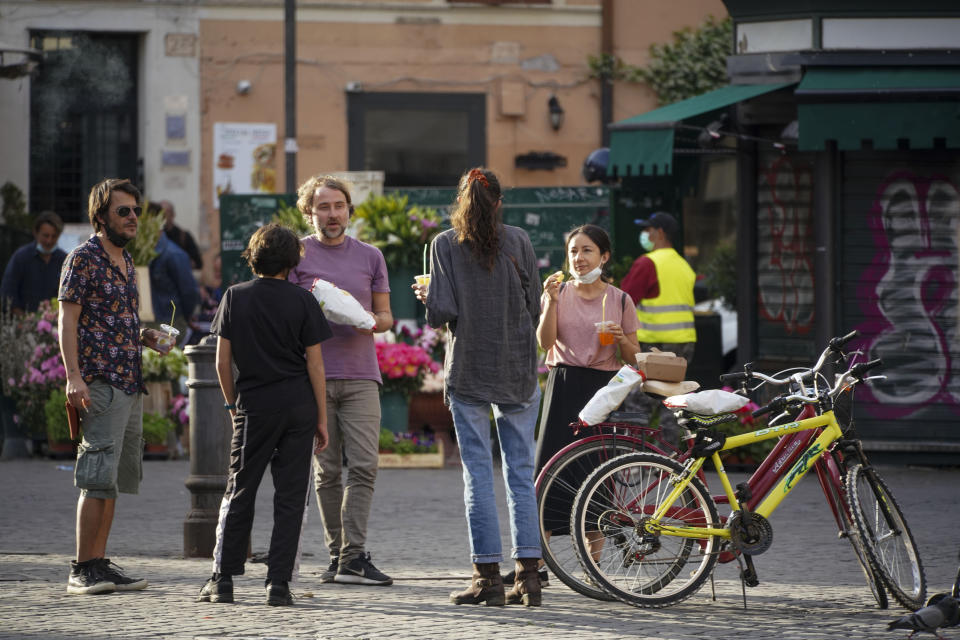 Gente disfruta de un paseo en la plaza Campo de' Fiori en Roma, qiue regresa lentamente a la vida después de la cuarentena prolongada impuesta por la pandemia de COVID-19, 8 de mayo de 2020. (AP Foto/Andrew Medichini)