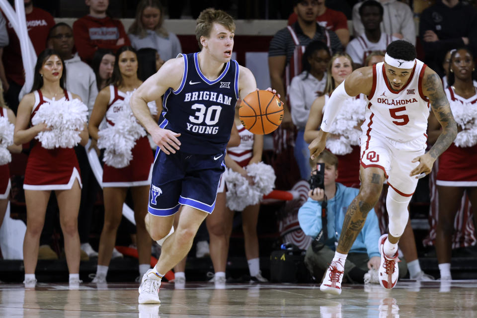 BYU guard Dallin Hall (30) brings the ball up as Oklahoma guard Rivaldo Soares (5) trails during the first half of an NCAA college basketball game Tuesday, Feb. 6, 2024, in Norman, Okla. (AP Photo/Garett Fisbeck)