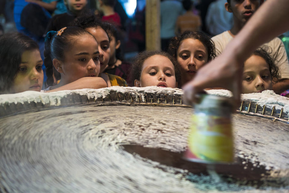 <p>Children gather around a man making Kunafa, a Middle Eastern dessert usually eaten during Ramadan, on a street at al-Baragel, Cairo, Egypt, May 25, 2017. (Photo: Mohamed Hossam/EPA) </p>