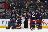 Columbus Blue Jackets head athletic trainer Mike Vogt, left, kneels and checks on Elvis Merzlikins (90), of Latvia, after Merzlikins was injured during the second period of an NHL hockey game against the Ottawa Senators, Monday, Feb. 24, 2020, in Columbus, Ohio. (AP Photo/Jay LaPrete)