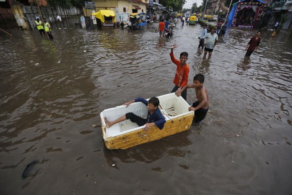 Indian children play in floodwaters after heavy rainfall in Ahmadabad, India, Friday, Aug. 17, 2018. India receives its annual rainfall from June-October. (AP Photo/Ajit Solanki)